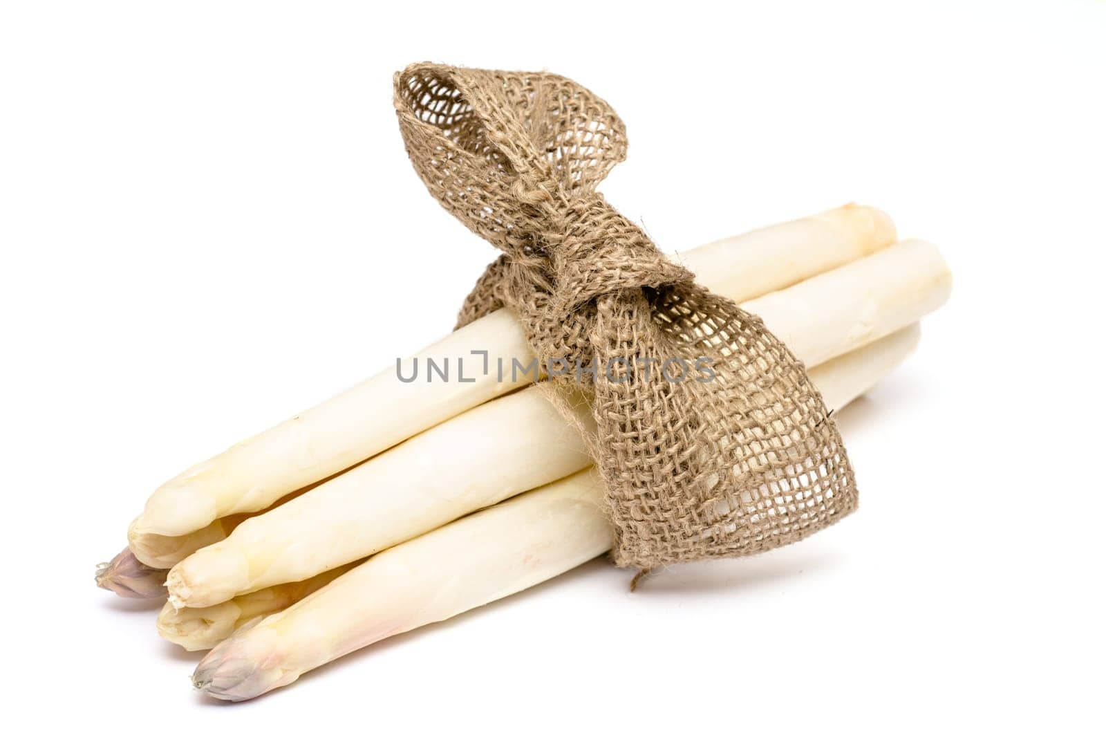 Bunch white asparagus with bow on white background