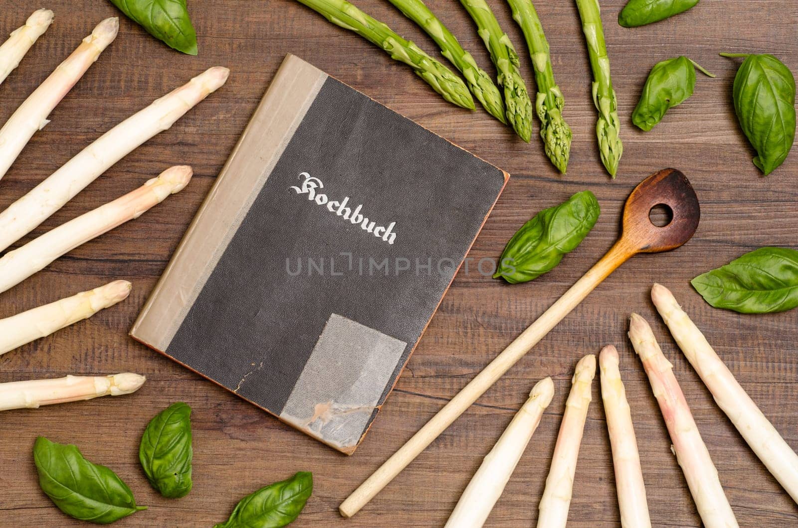 Cookbook with cooking spoon and white and green asparagus