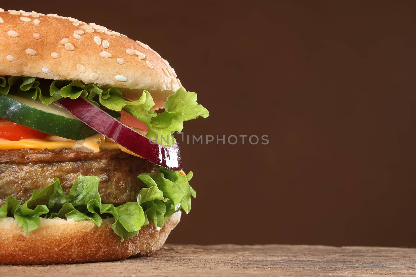 Tasty hamburger on wood background. Lots of ingredients