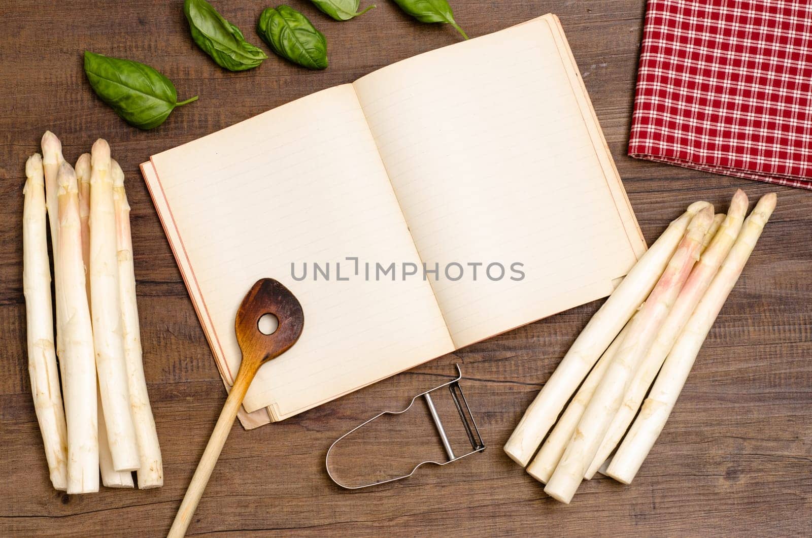 Book with text freedom,cooking spoon,asparagus,basil,napkin and peeler