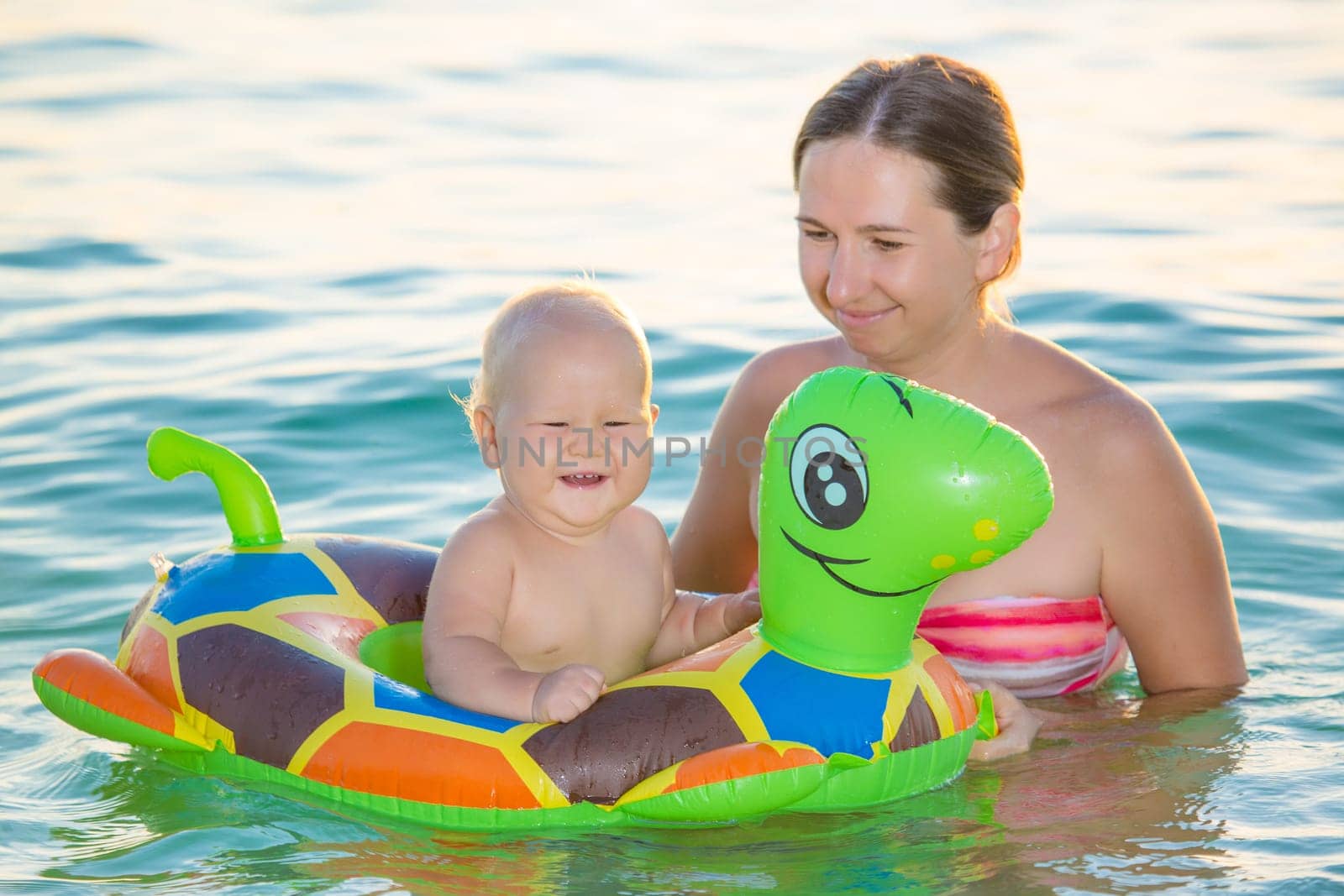 Baby and mother having fun time in the sea