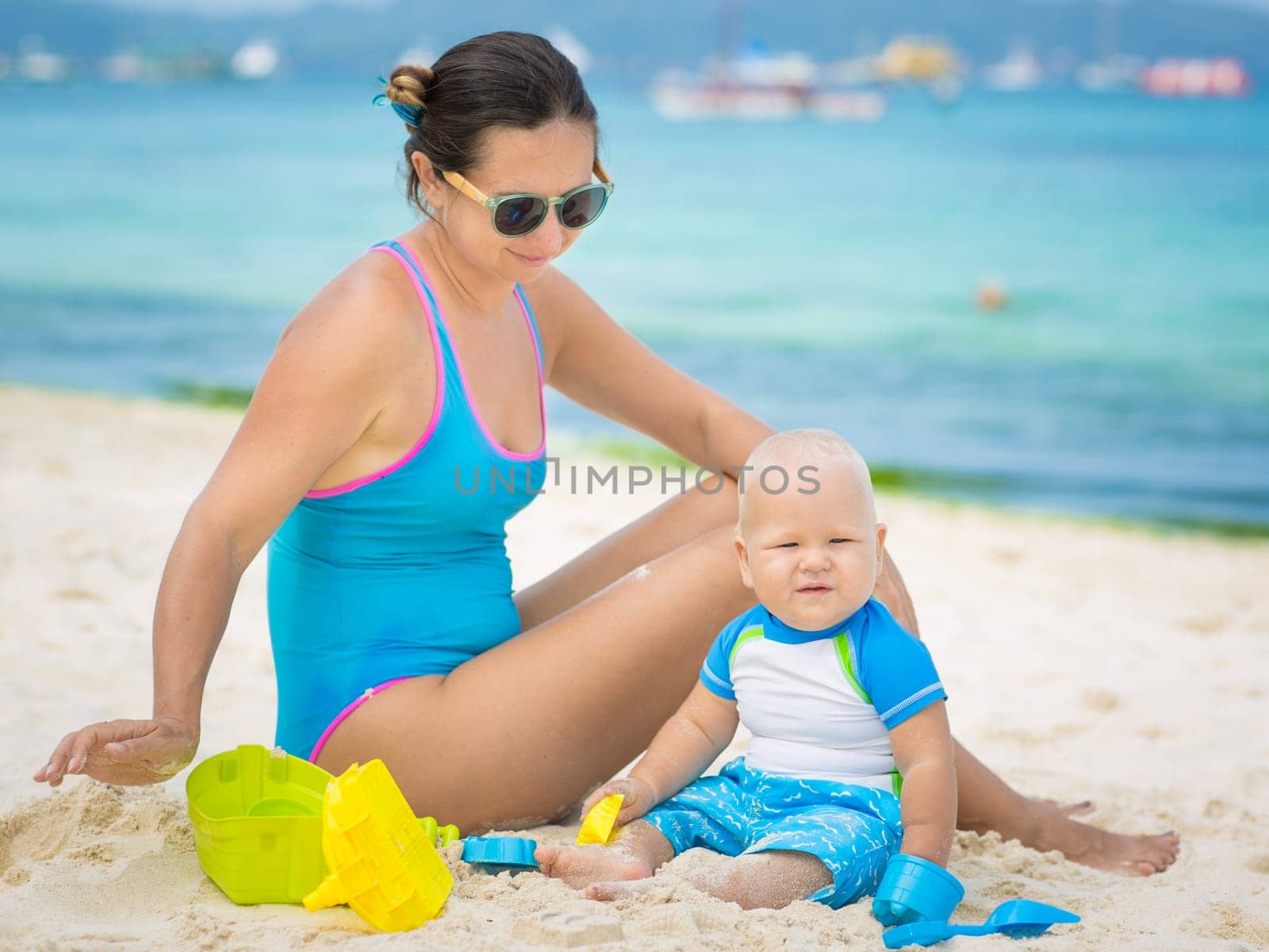 Baby and mom are playing beach toys