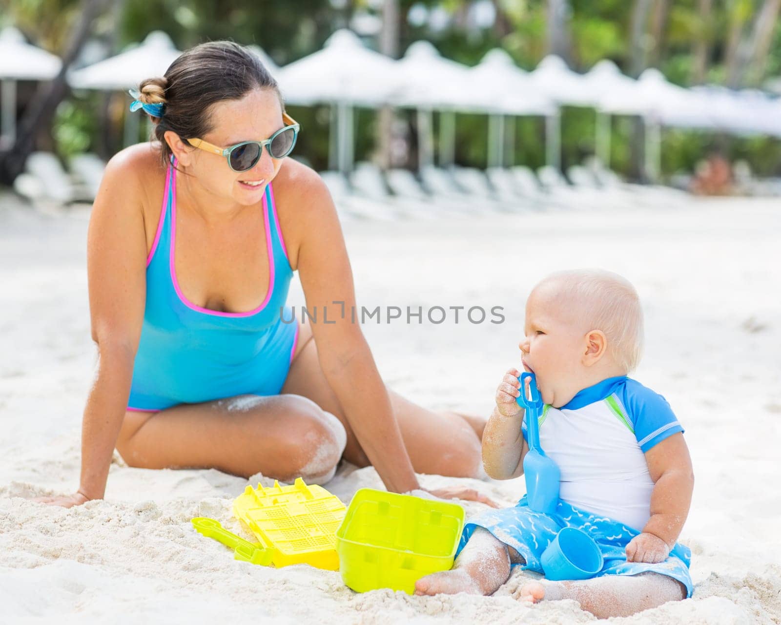 Baby and mom are playing beach toys