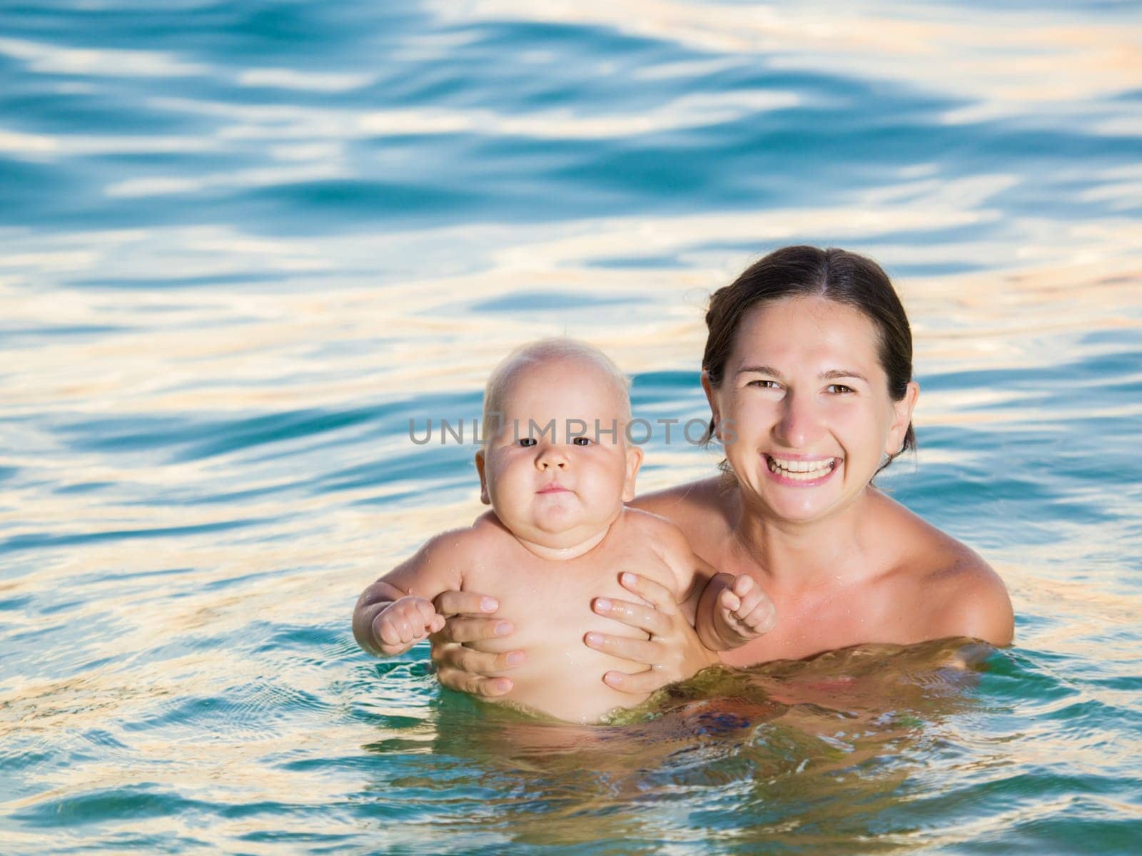 Baby and mother having fun time in the sea