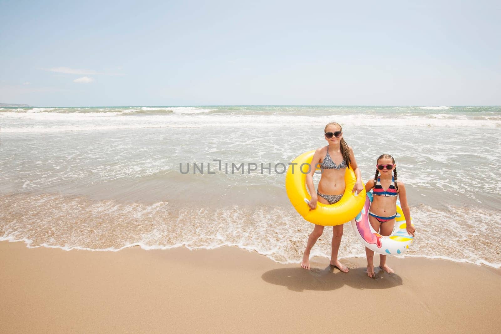 Two girls having fun on a beautiful beach in the summertime