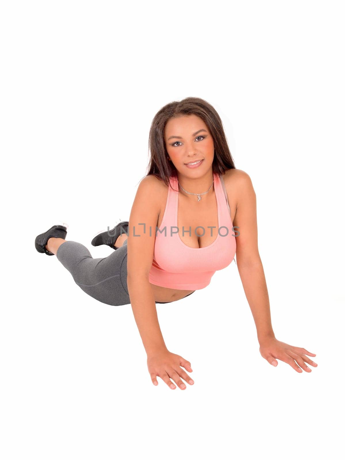 A young pretty woman lying on the floor and doing push up's.isolated on white background..