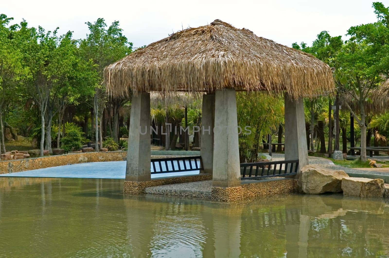 The pavilion with thatch roof beside swimming pool