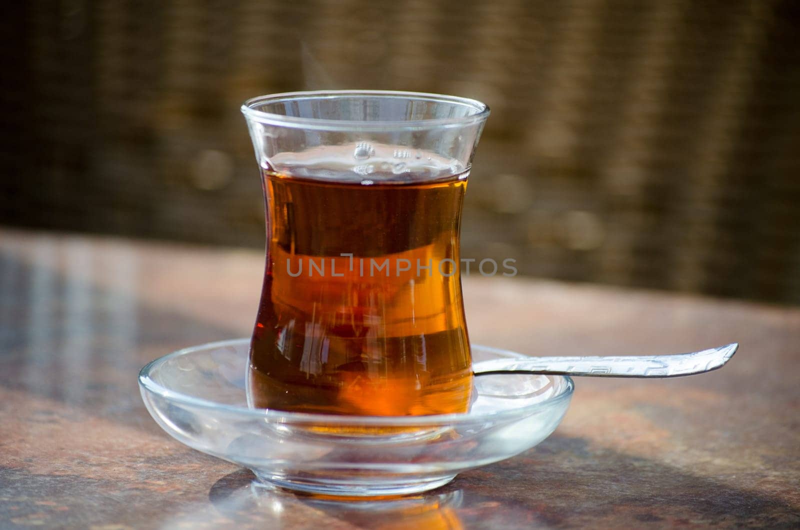 Turkish tea in glass and spoon on a table.