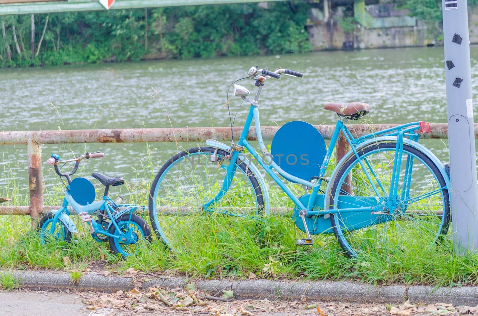 A large women's bike and a small blue children's bike on the shore.