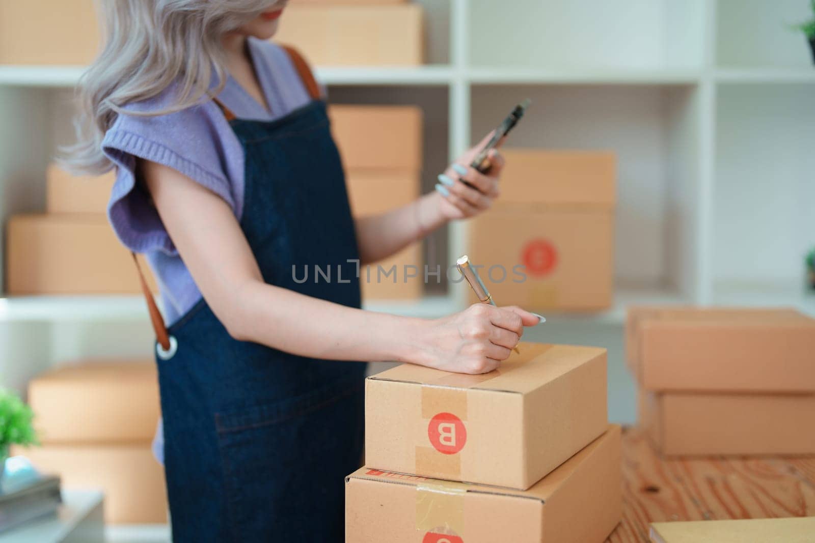 Asian female business owner handles delivery of orders to customers.