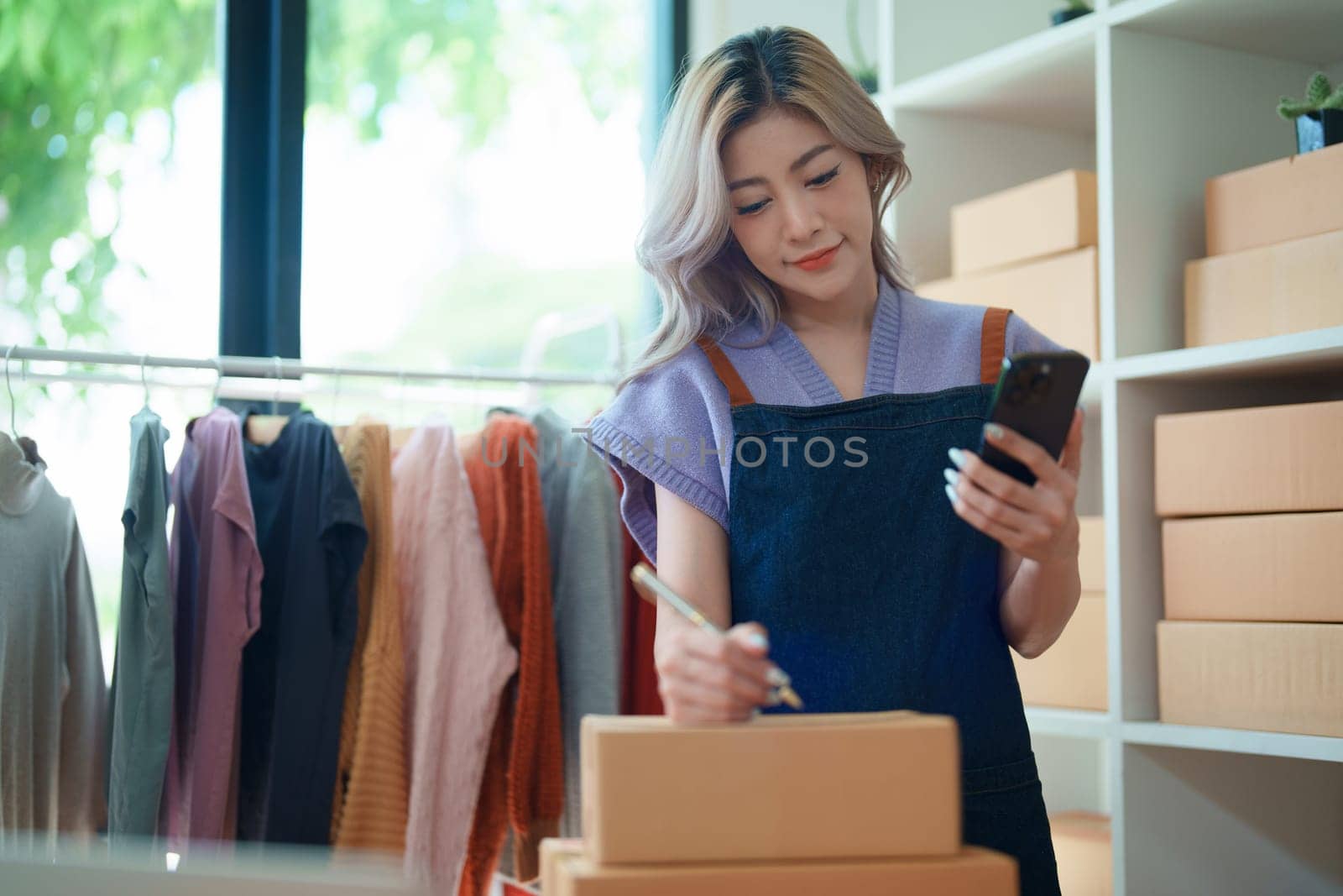 Asian female business owner handles delivery of orders to customers by Manastrong