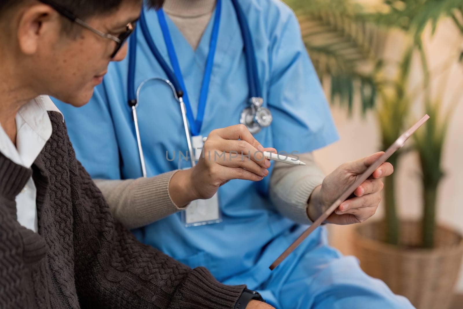 Asian nurse showing health checkup report to older and giving advice. Home nursing and healthcare caregiver concept.