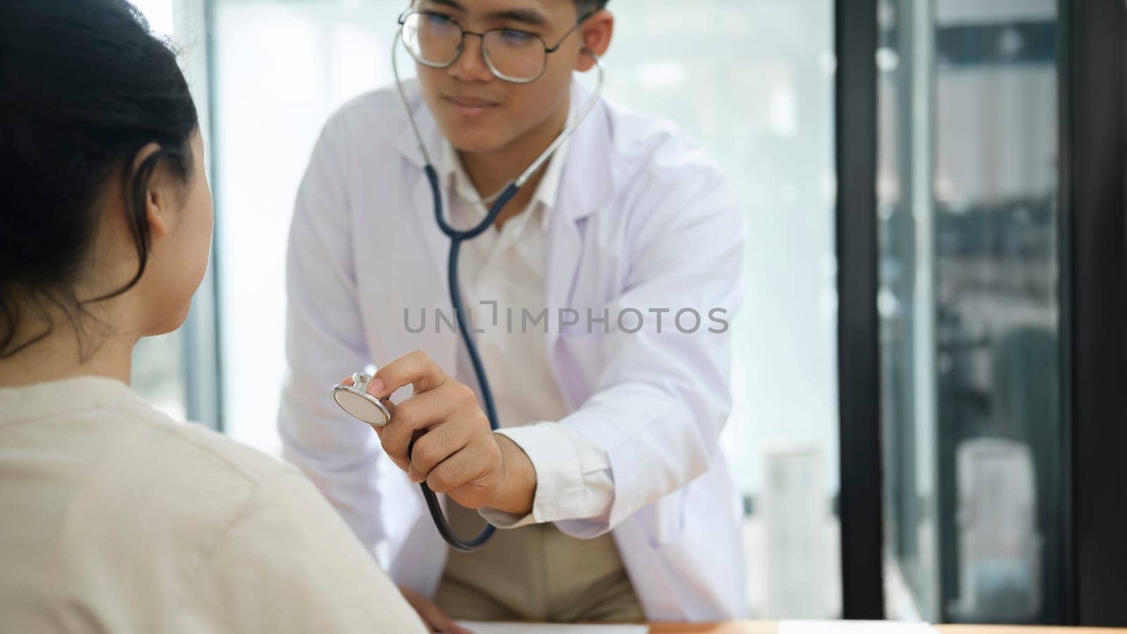 Young doctor is using a stethoscope listen to the heartbeat of the patient. by ijeab