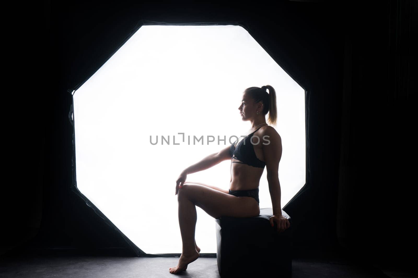 Silhouette of beautiful young woman wearing underwear in backlight