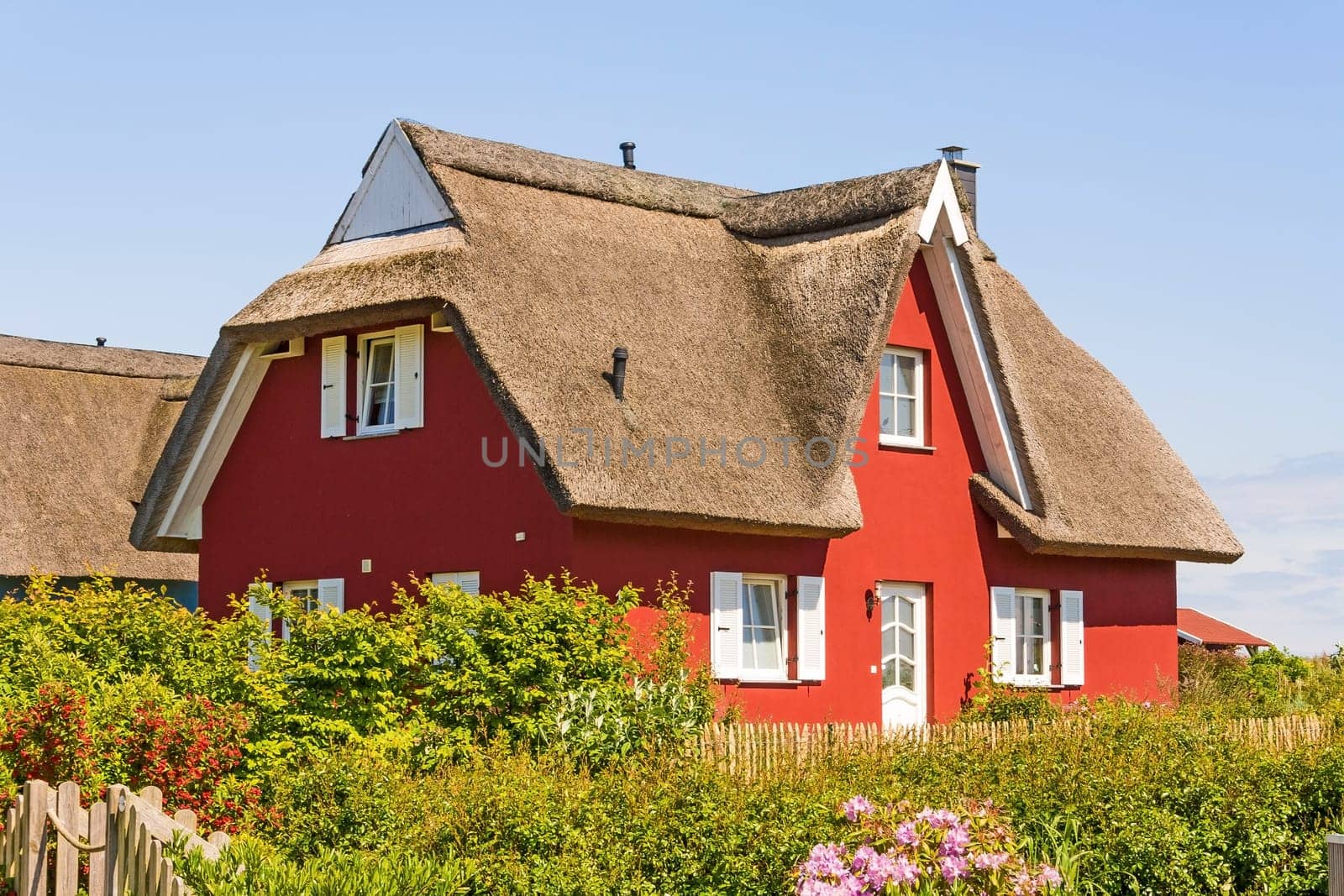 red thatched-roof vacation home with garden
