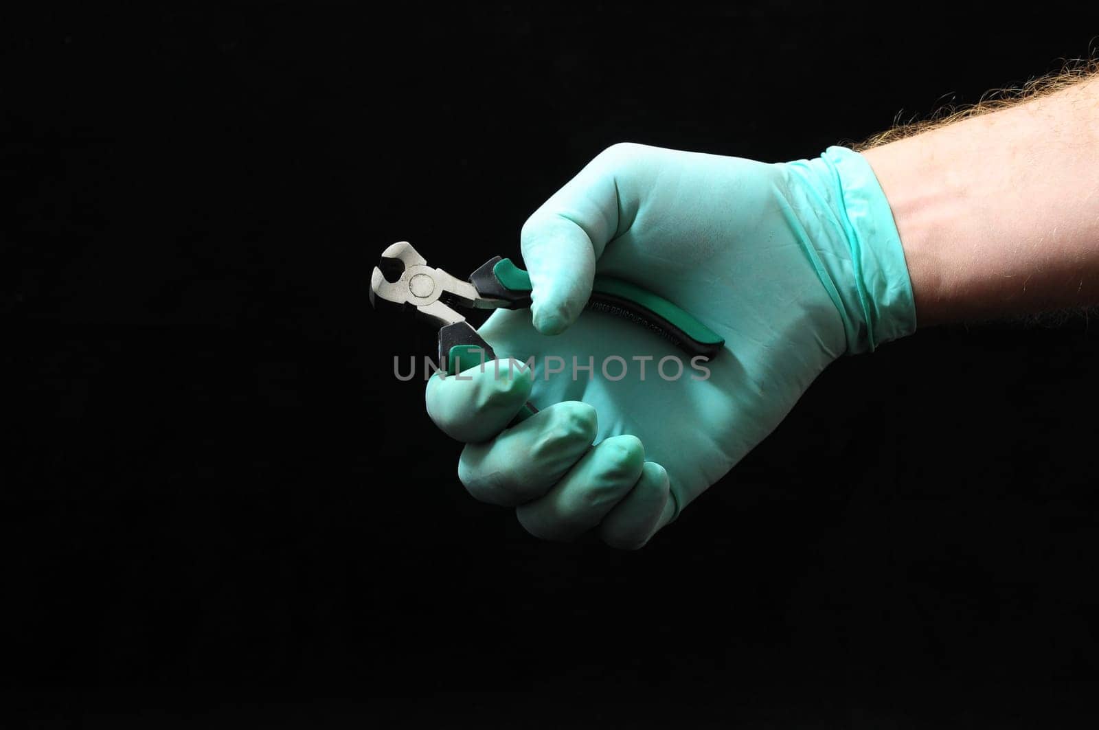 Cutter Pliers and a Hand on a Black Background