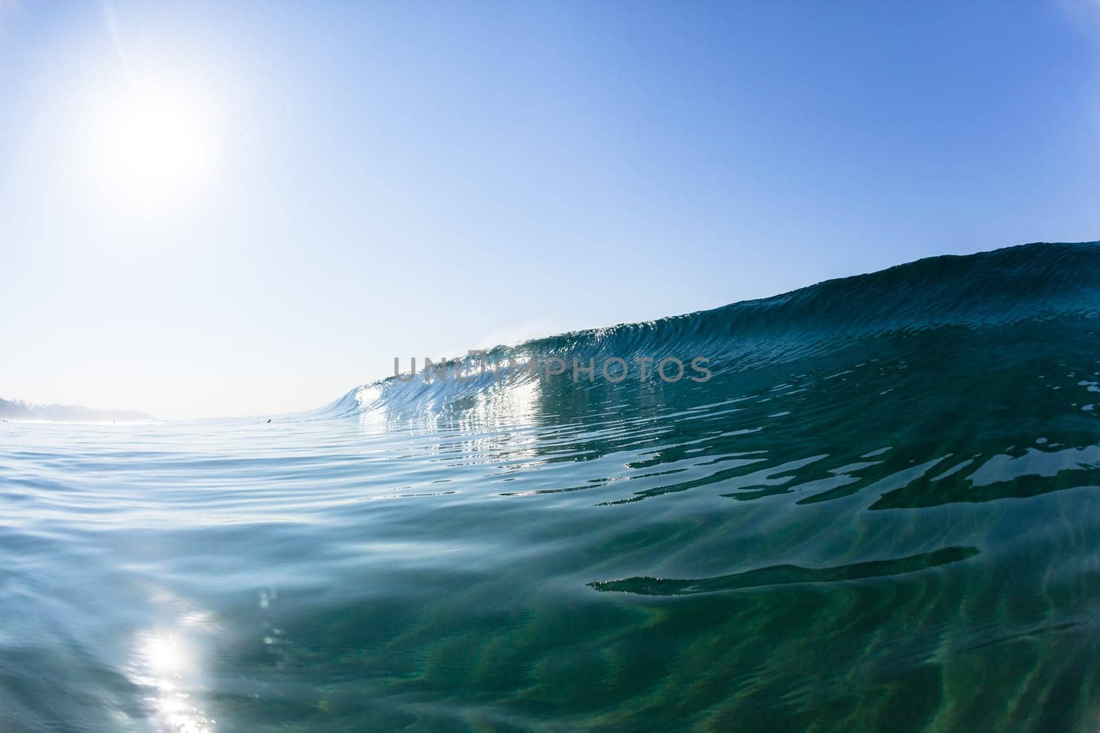 Ocean sea wave vertical crashing hollow tubing water power on shallow beach reefs sandbars, a swimming surfer action water photo