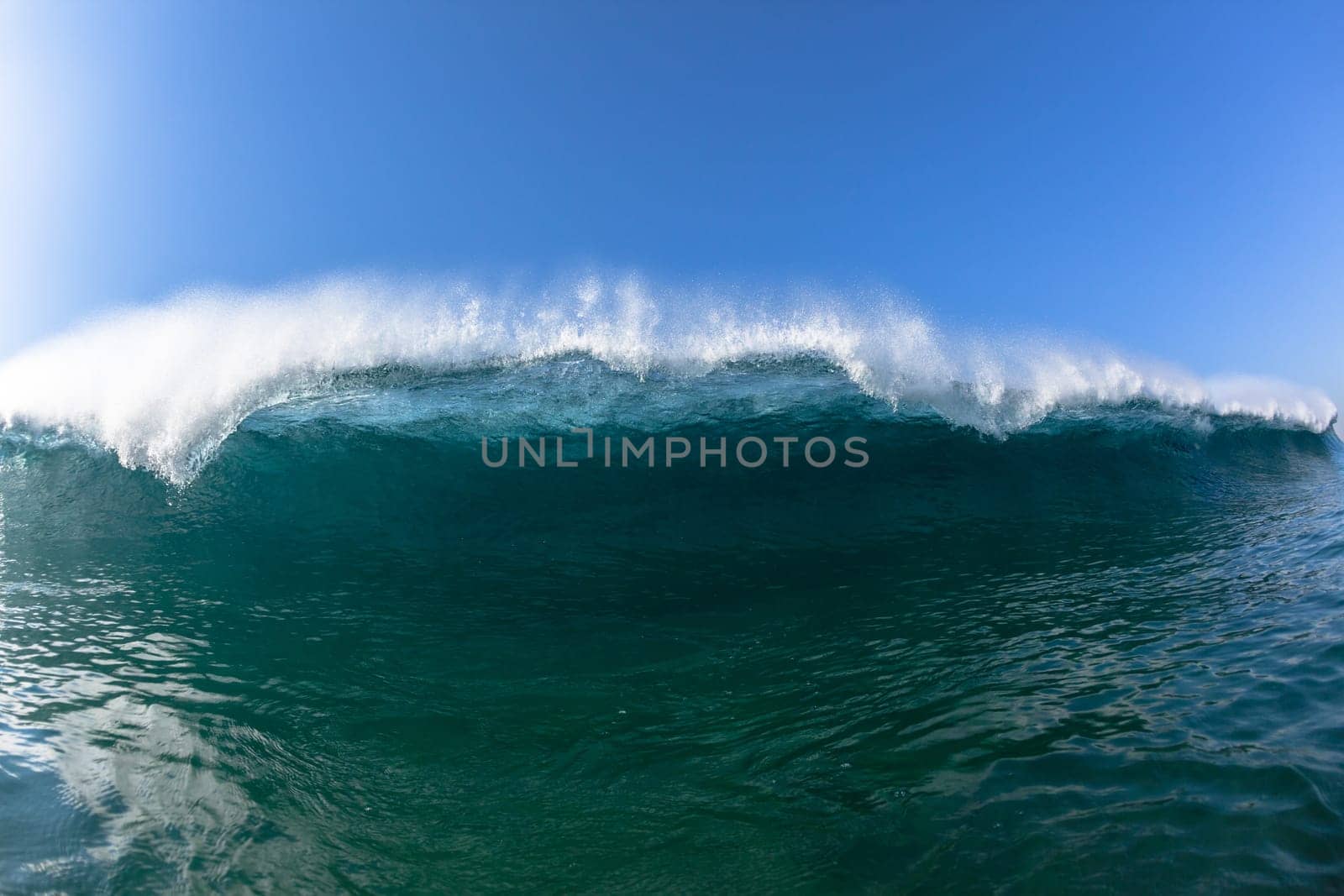 Ocean sea wave vertical crashing hollow tubing water power on shallow beach reefs sandbars, a swimming surfer action water photo