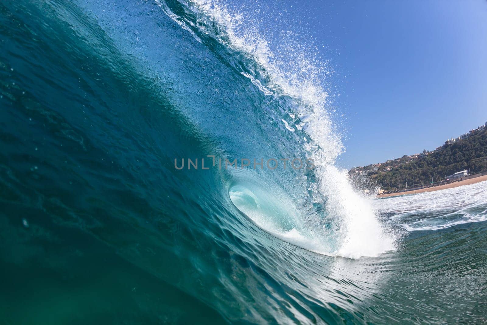 Ocean sea wave vertical crashing hollow tubing water power on shallow beach reefs sandbars, a swimming surfer action water photo