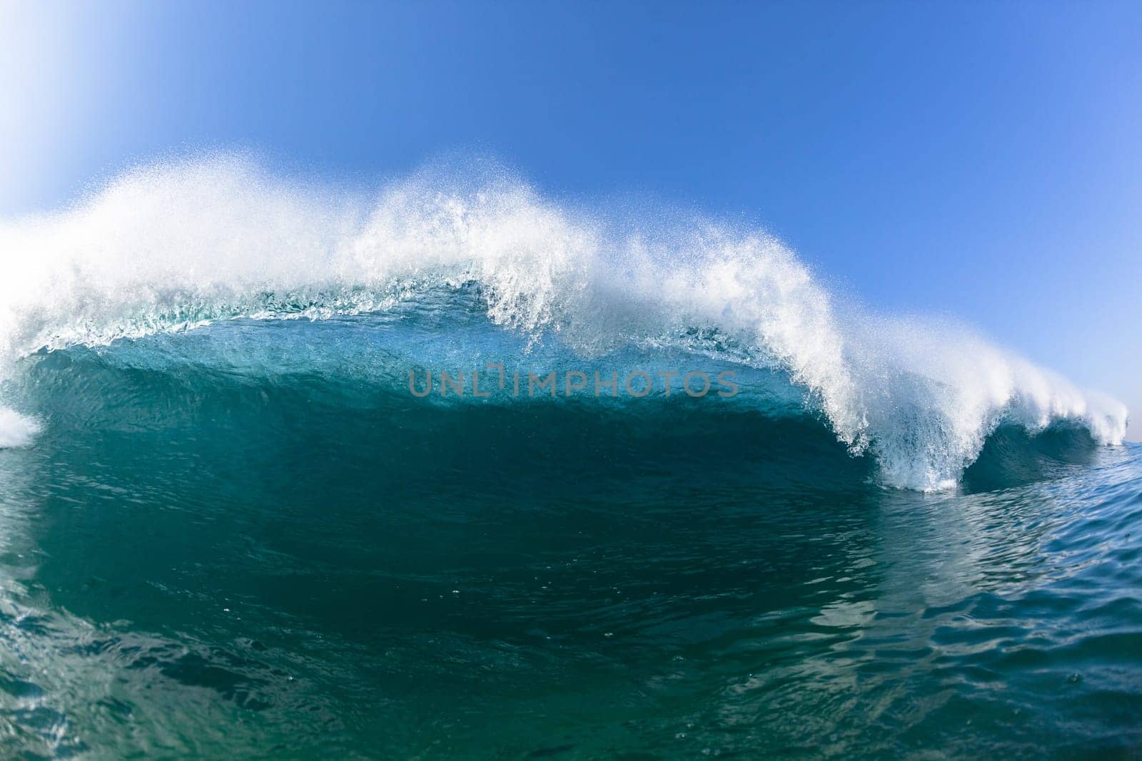 Ocean sea wave vertical crashing hollow tubing water power on shallow beach reefs sandbars, a swimming surfer action water photo