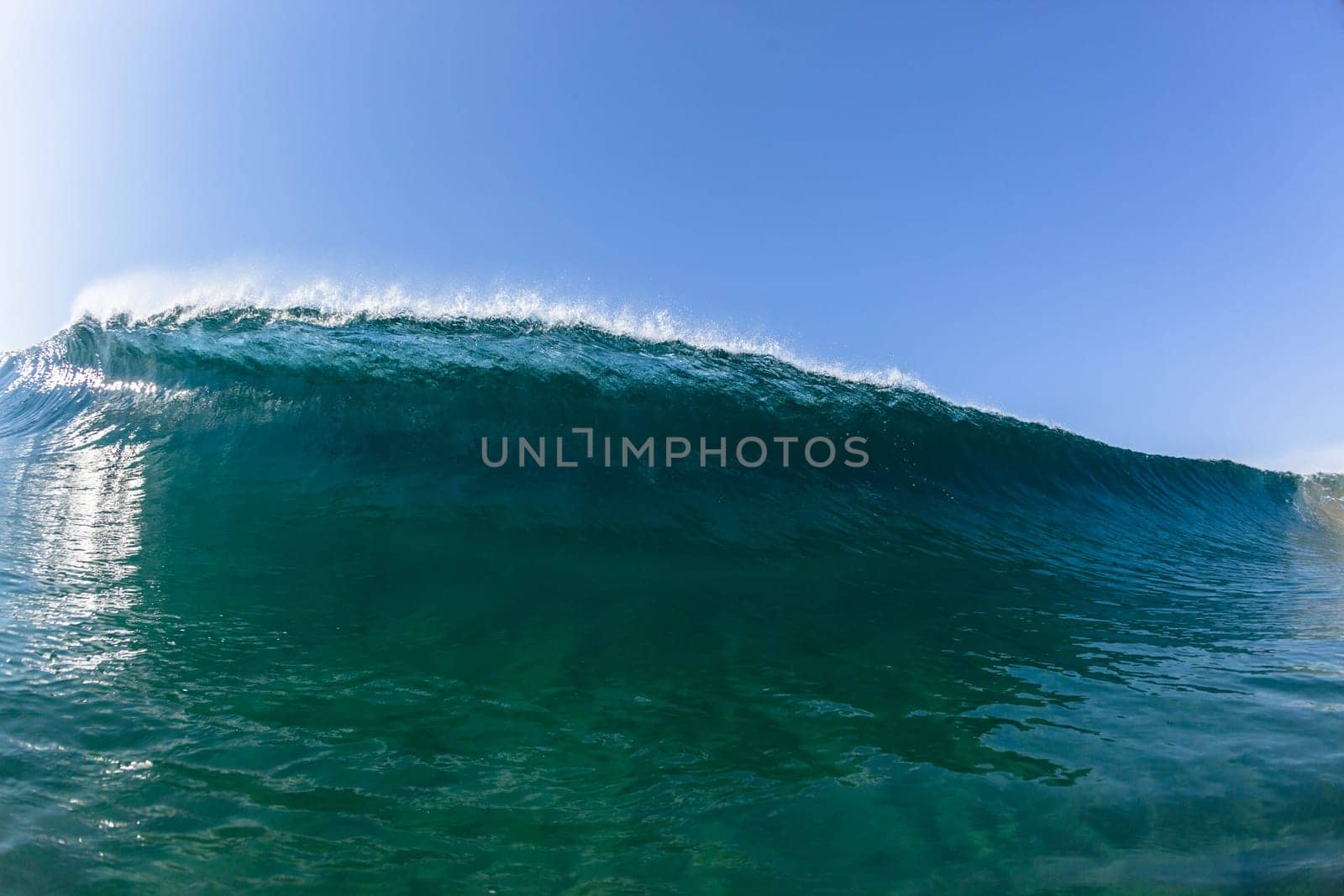 Ocean sea wave vertical crashing hollow tubing water power on shallow beach reefs sandbars, a swimming surfer action water photo