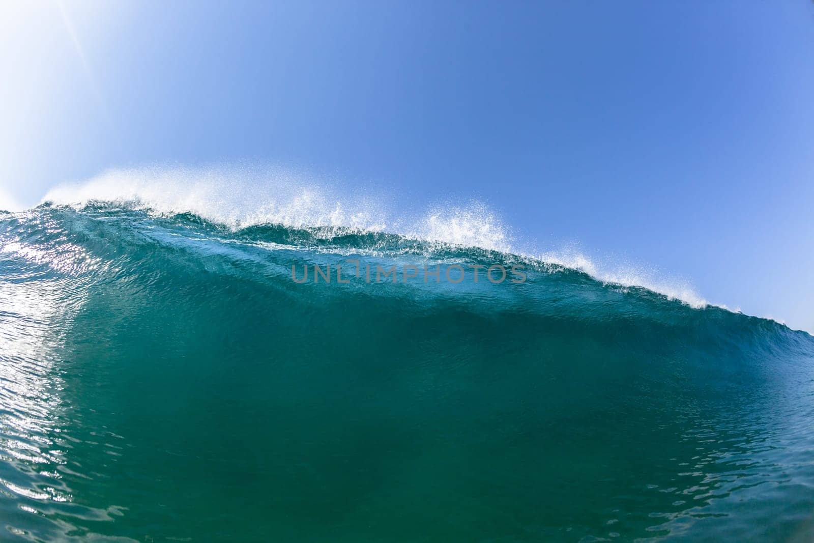 Ocean sea wave vertical crashing hollow tubing water power on shallow beach reefs sandbars, a swimming surfer action water photo