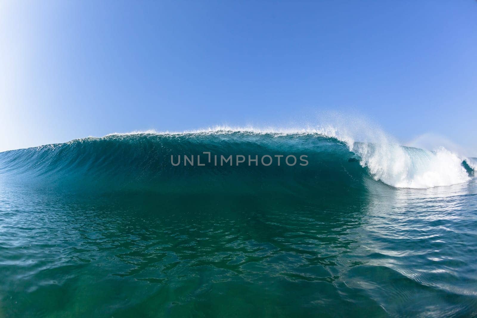 Ocean sea wave vertical crashing hollow tubing water power on shallow beach reefs sandbars, a swimming surfer action water photo