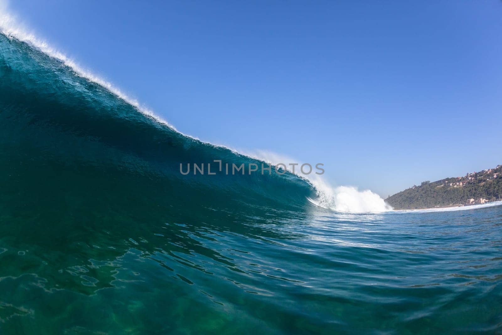 Ocean sea wave vertical crashing hollow tubing water power on shallow beach reefs sandbars, a swimming surfer action water photo