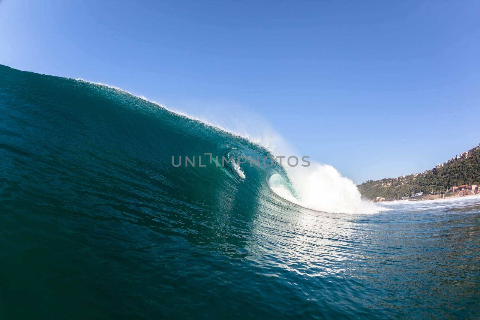 Ocean sea wave vertical crashing hollow tubing water power on shallow beach reefs sandbars, a swimming surfer action water photo