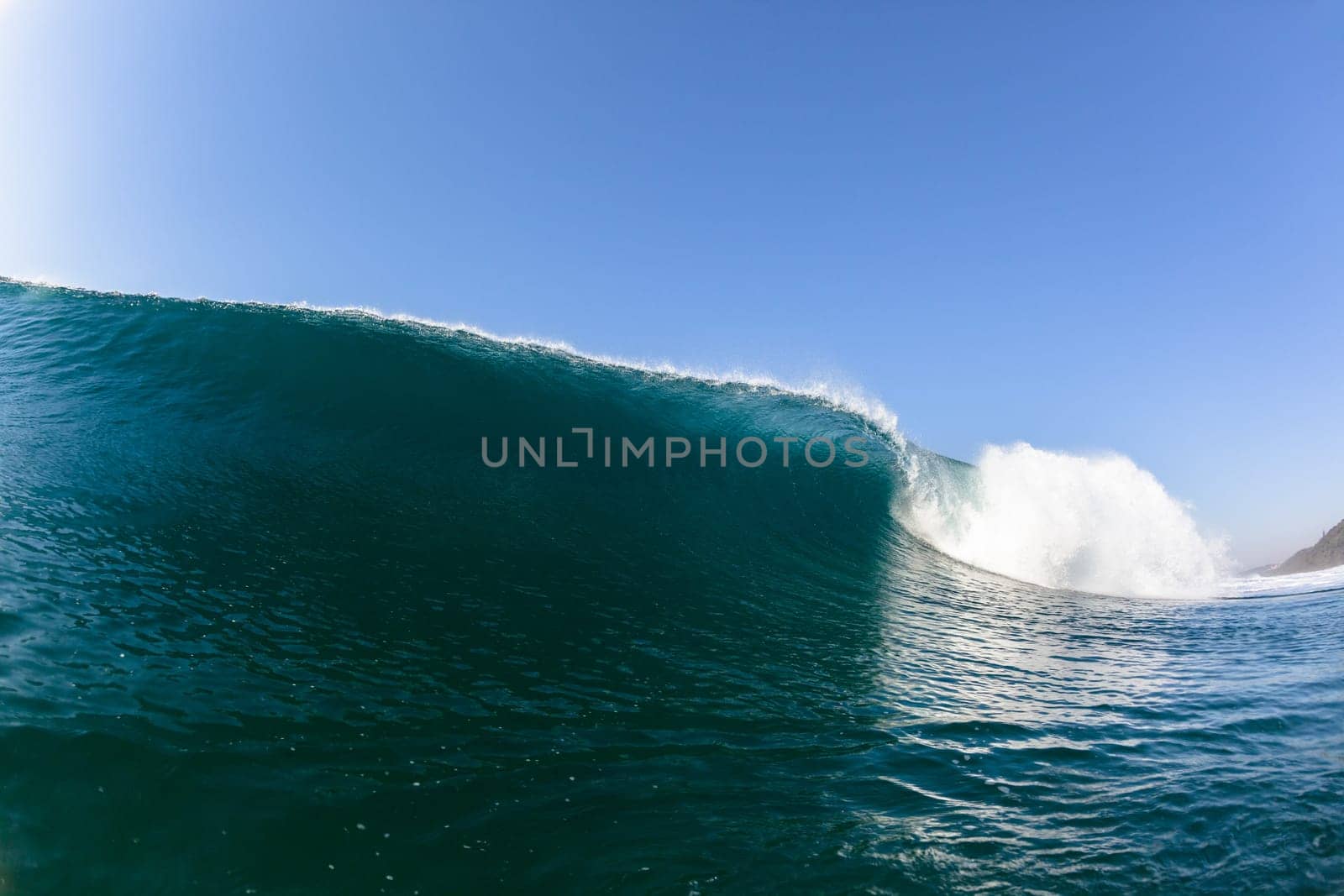 Ocean sea wave vertical crashing hollow tubing water power on shallow beach reefs sandbars, a swimming surfer action water photo