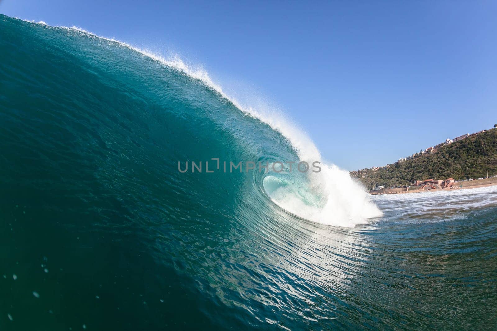 Ocean sea wave vertical crashing hollow tubing water power on shallow beach reefs sandbars, a swimming surfer action water photo