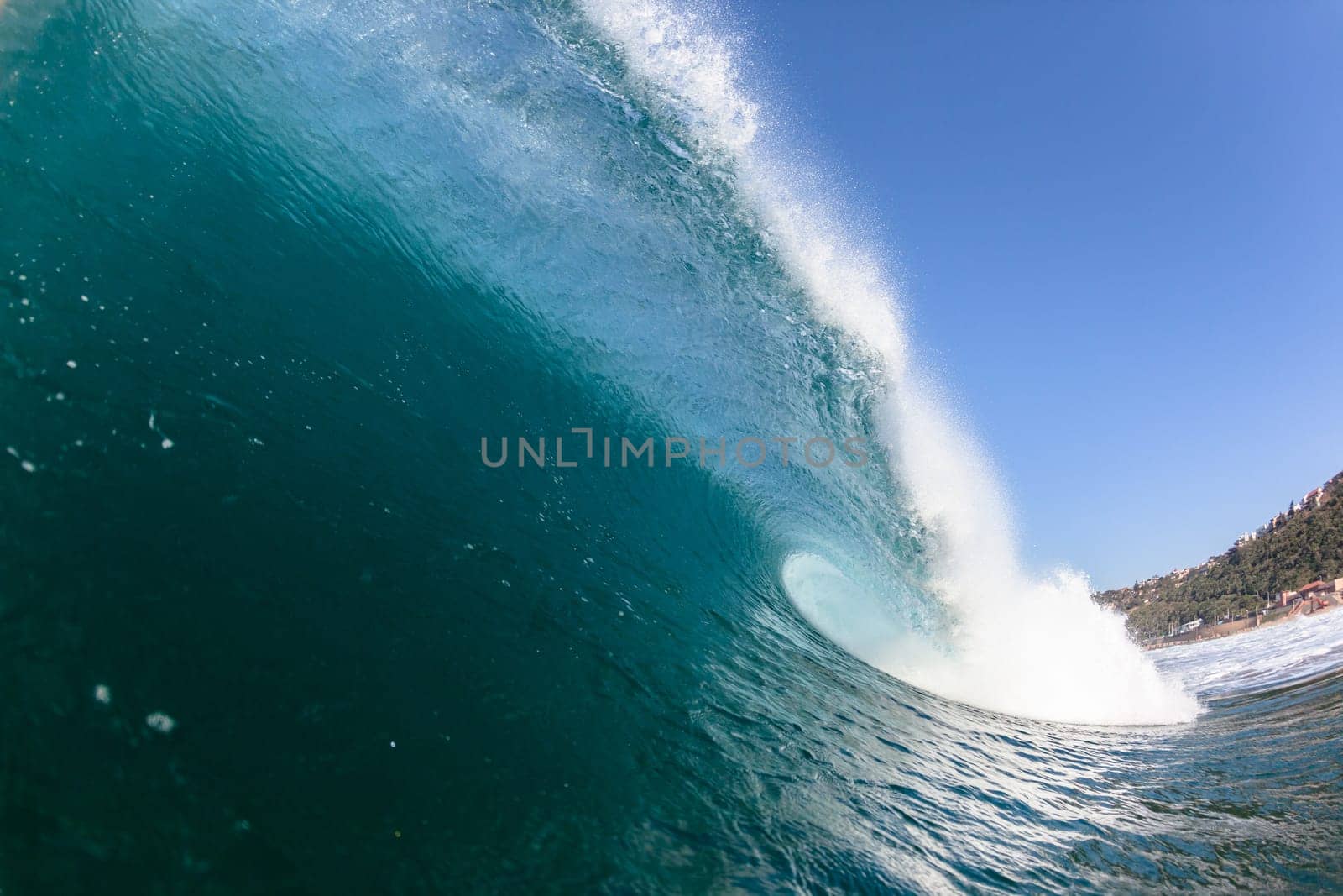 Ocean sea wave vertical crashing hollow tubing water power on shallow beach reefs sandbars, a swimming surfer action water photo