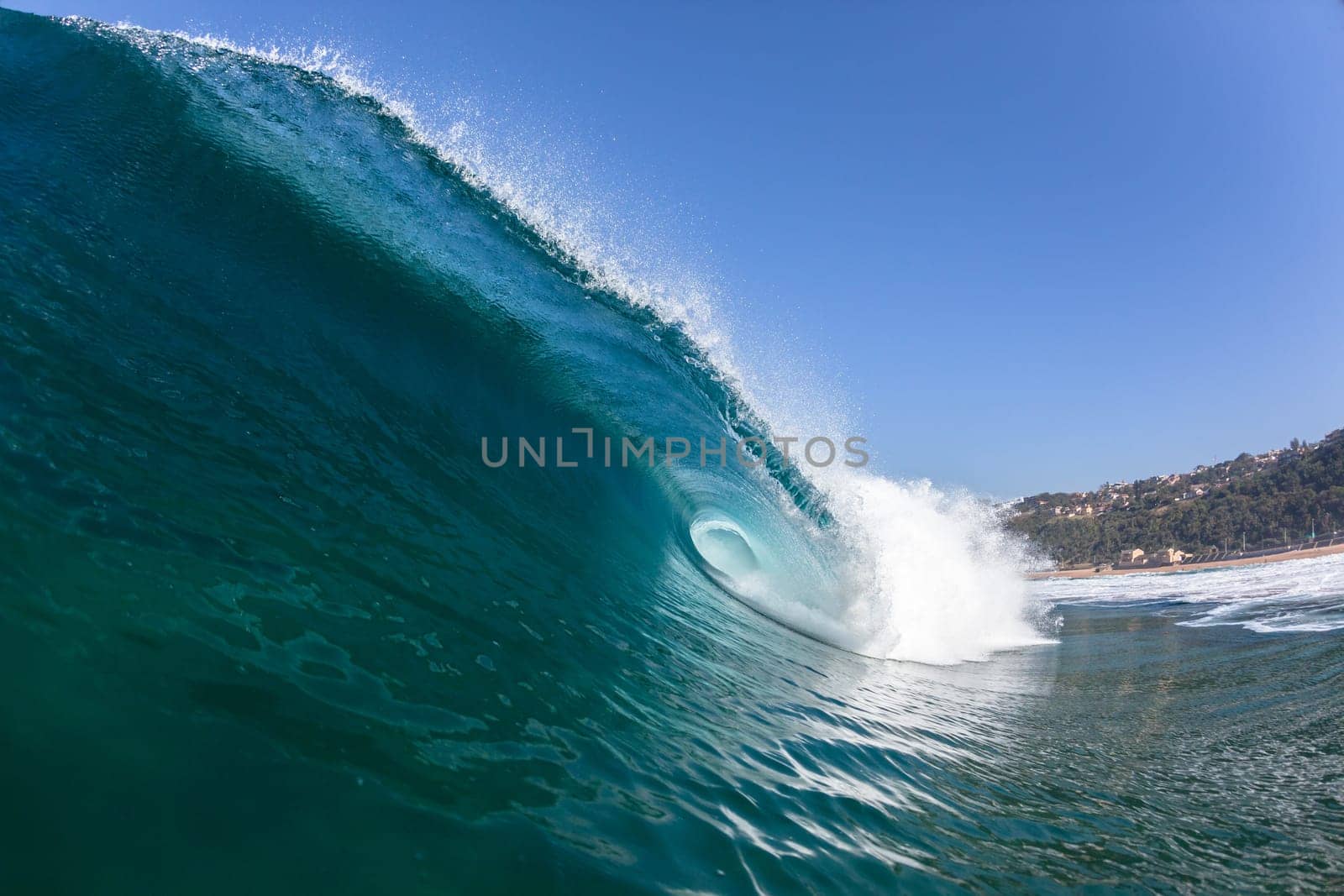 Ocean sea wave vertical crashing hollow tubing water power on shallow beach reefs sandbars, a swimming surfer action water photo