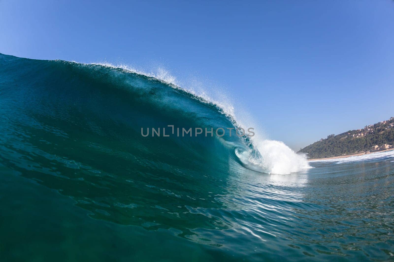 Ocean sea wave vertical crashing hollow tubing water power on shallow beach reefs sandbars, a swimming surfer action water photo