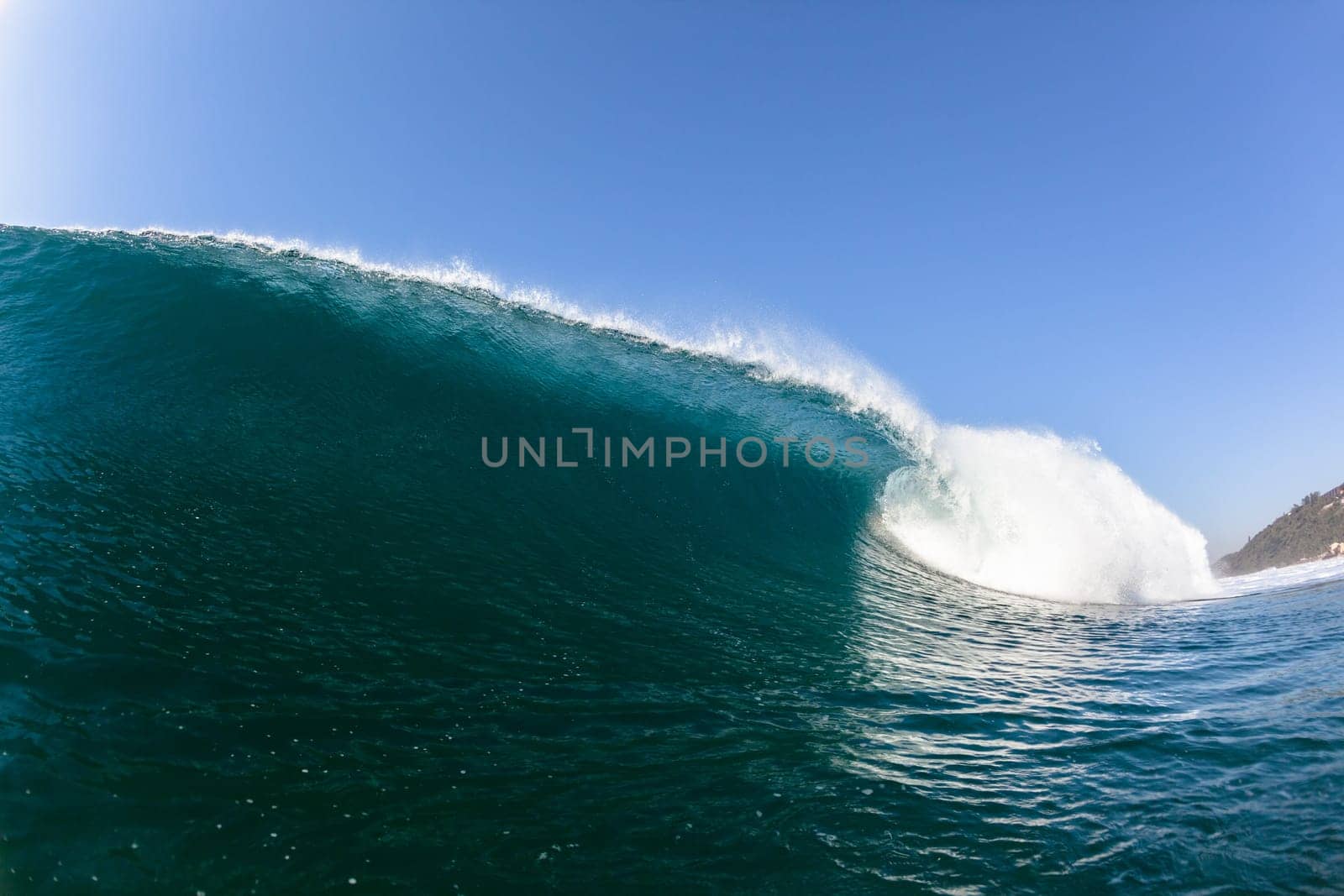 Ocean sea wave vertical crashing hollow tubing water power on shallow beach reefs sandbars, a swimming surfer action water photo