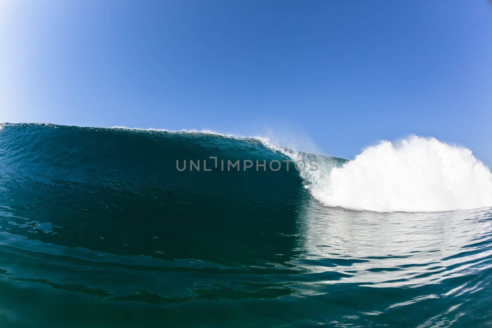 Ocean sea wave vertical crashing hollow tubing water power on shallow beach reefs sandbars, a swimming surfer action water photo
