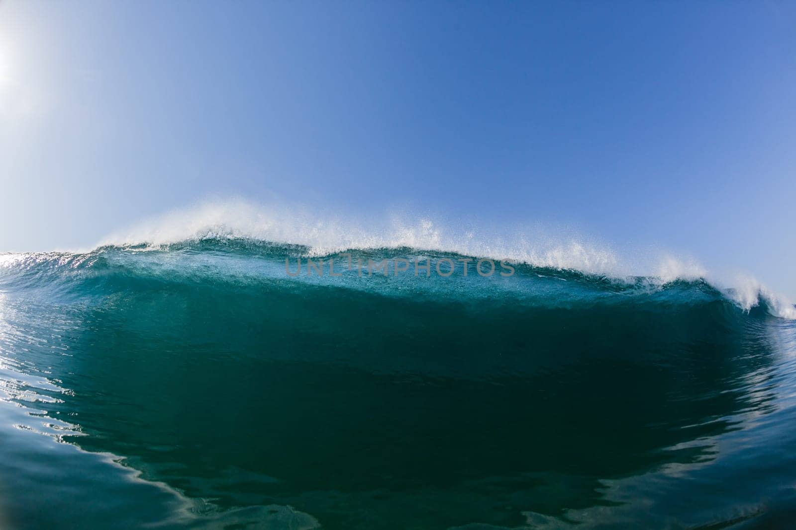Ocean sea wave vertical crashing hollow tubing water power on shallow beach reefs sandbars, a swimming surfer action water photo