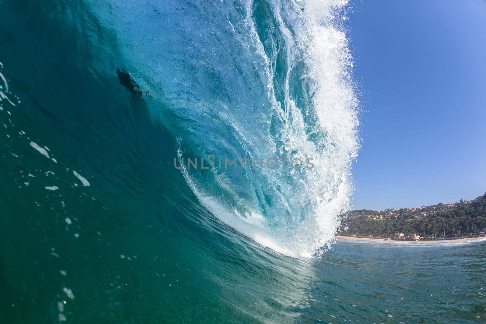 Ocean sea wave vertical crashing hollow tubing water power on shallow beach reefs sandbars, a swimming surfer action water photo
