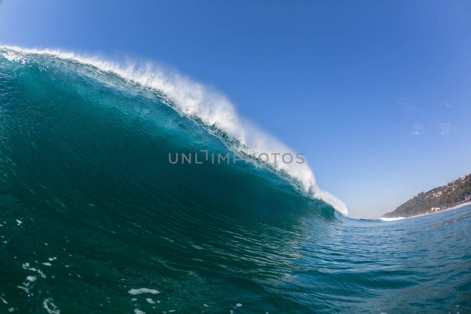 Ocean sea wave vertical crashing hollow tubing water power on shallow beach reefs sandbars, a swimming surfer action water photo