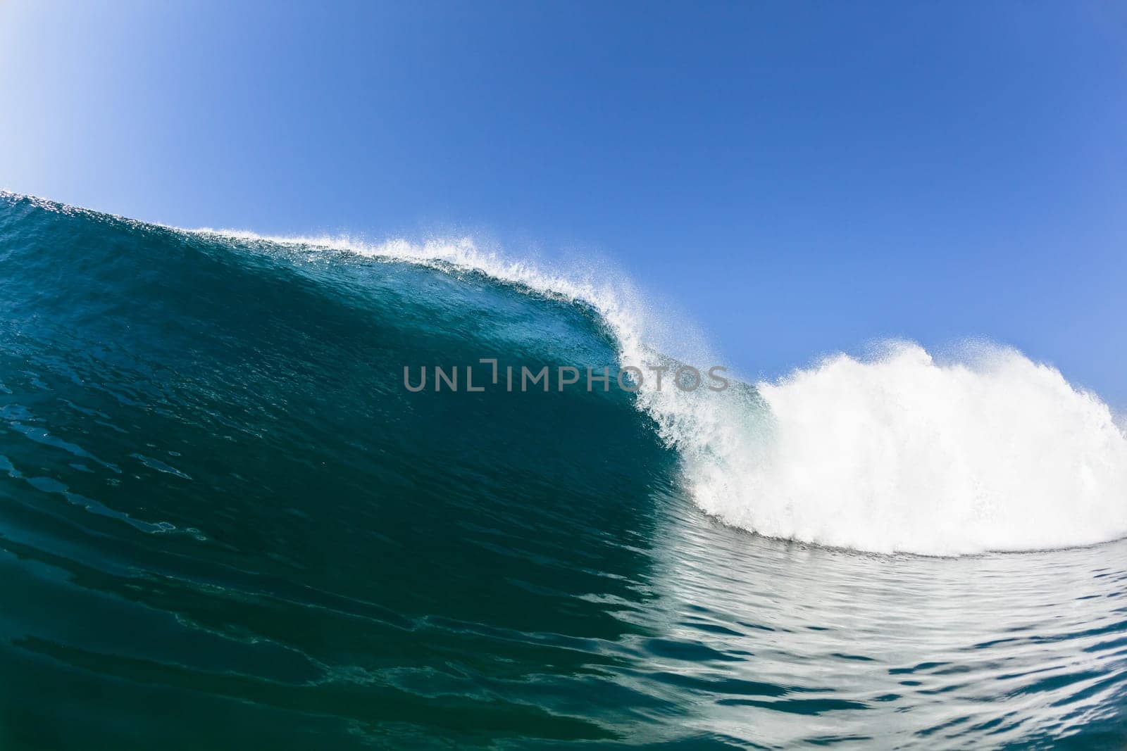 Ocean sea wave vertical crashing hollow tubing water power on shallow beach reefs sandbars, a swimming surfer action water photo