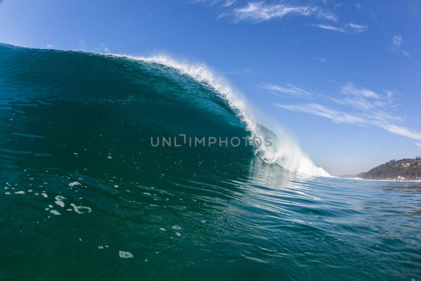 Ocean sea wave vertical crashing hollow tubing water power on shallow beach reefs sandbars, a swimming surfer action water photo