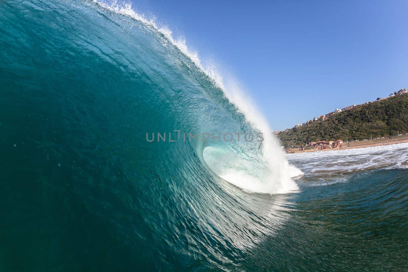 Ocean sea wave vertical crashing hollow tubing water power on shallow beach reefs sandbars, a swimming surfer action water photo