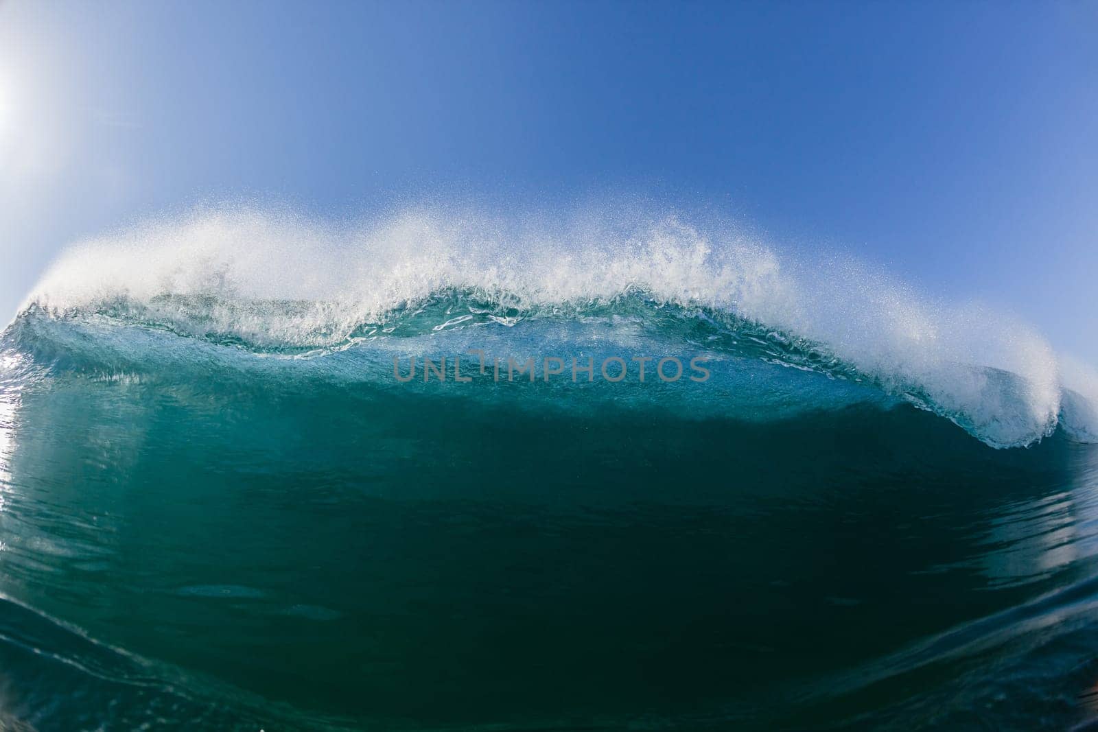 Ocean sea wave vertical crashing hollow tubing water power on shallow beach reefs sandbars, a swimming surfer action water photo