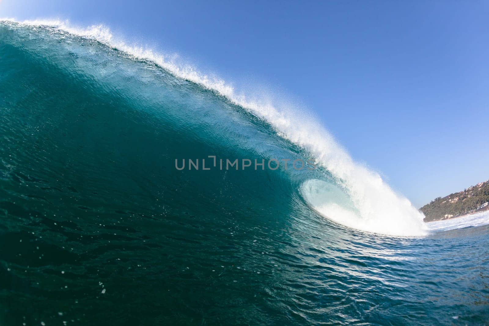 Ocean sea wave vertical crashing hollow tubing water power on shallow beach reefs sandbars, a swimming surfer action water photo