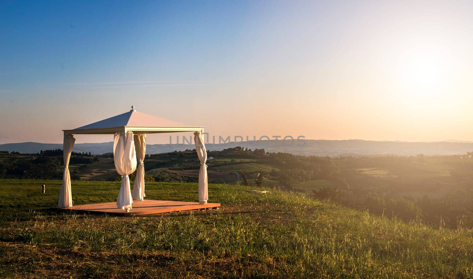 White gazebo in a mountain. Sun lights.