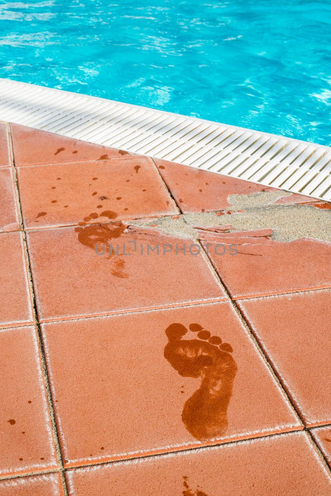 Footprints of bare feet to swimming pool. Water footprints