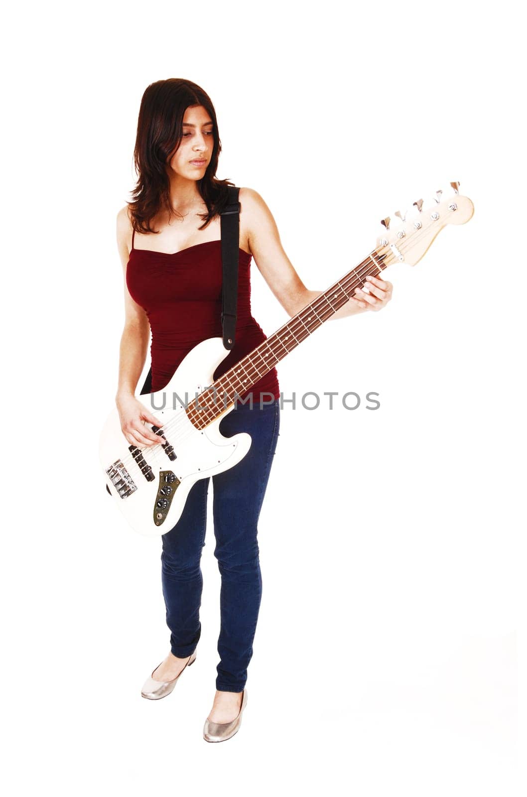 A young woman standing in the studio, playing her guitar, isolated on white.background..