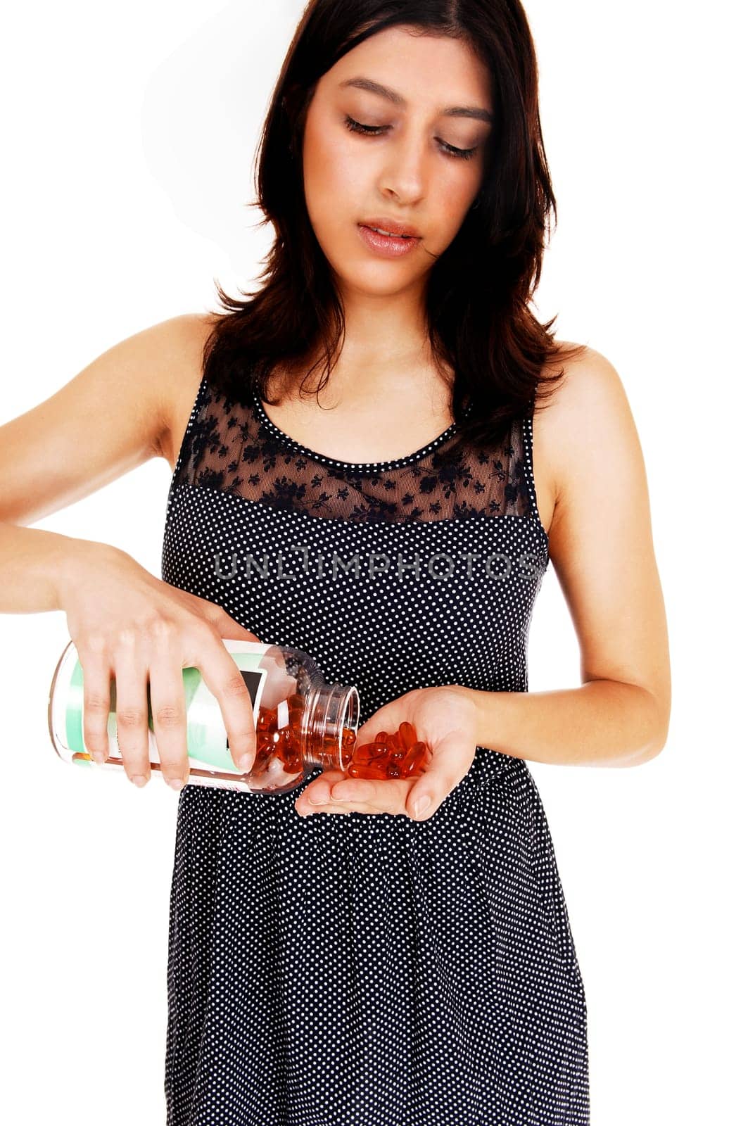 A closeup picture of a young woman pouring some vitamin pills in her hand.isolated on white background..