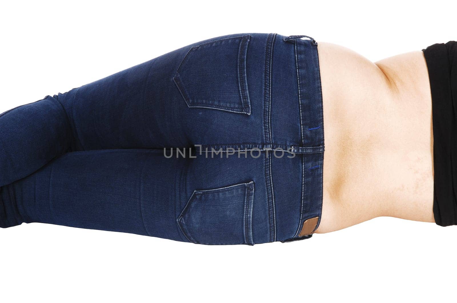 A young woman in jeans lying from the back on the floor showing her.behind, isolated on white background..
