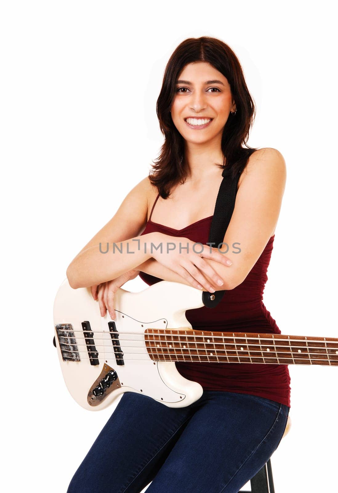 A young woman sitting on a chair, holding her guitar, isolated on white.background..